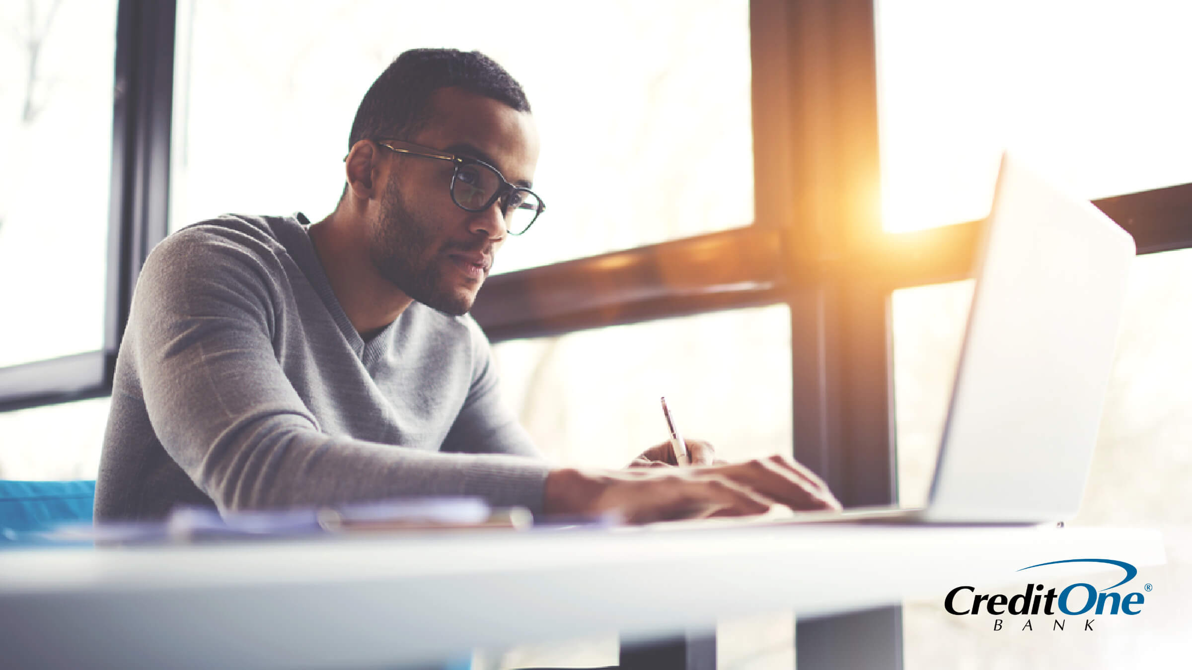 Man seated, starting at computer screen as he applies to credit cards